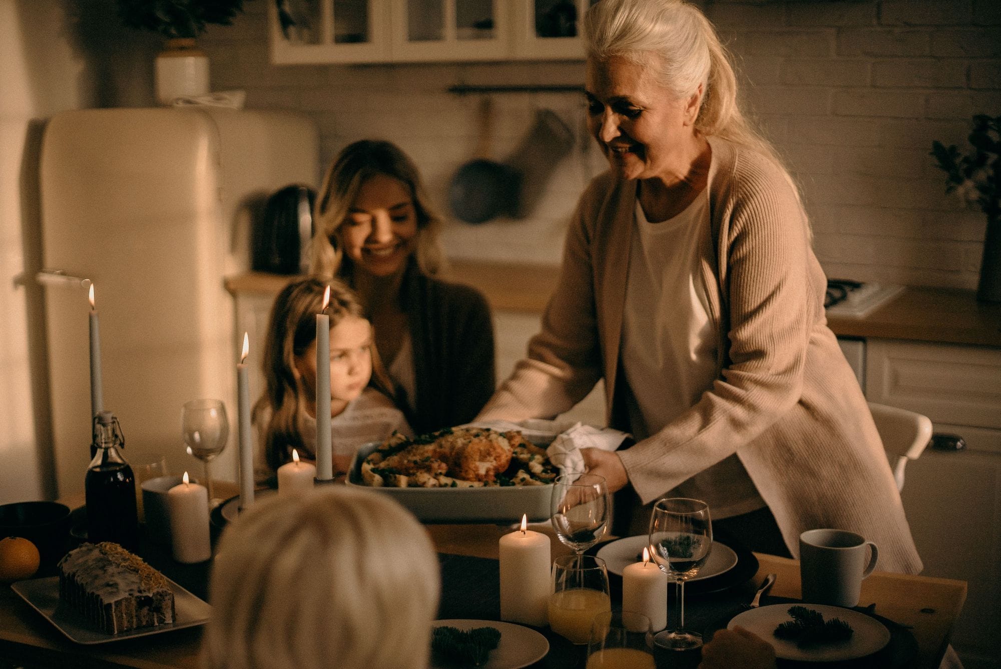 Three generations of a family sharing a home-cooked meal together in a warm kitchen.